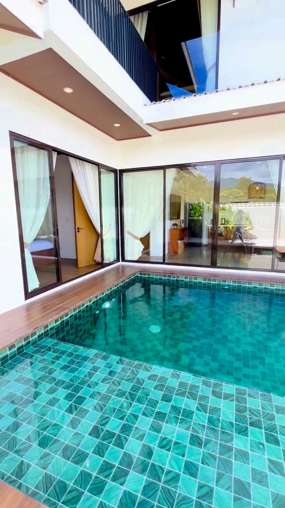 Villa Indra — turquoise tiled private pool with glass doors opening to the bedroom