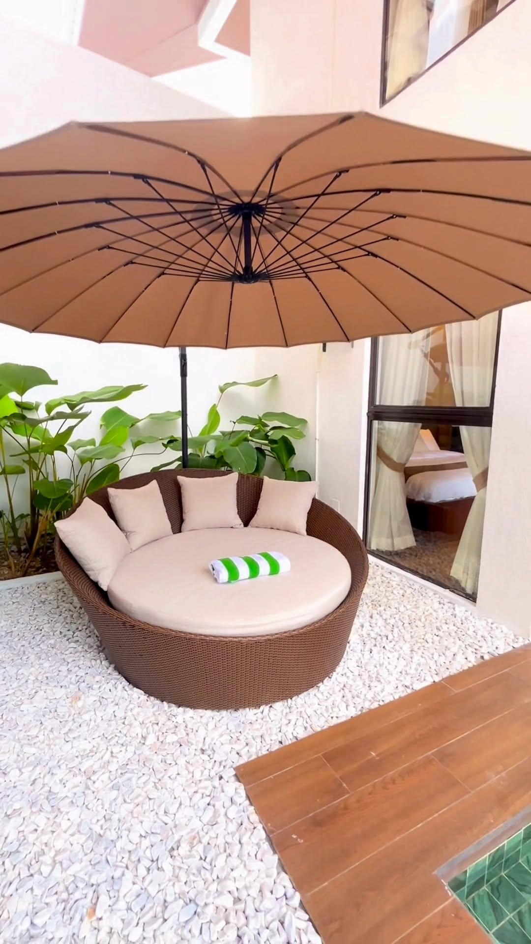 Villa Anvi — rattan circular daybed under umbrella overlooking the turquoise pool