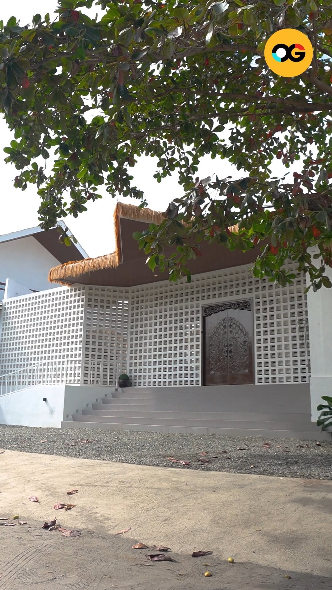 Ayatana exterior — white breeze-block facade with carved ornate doors and thatched roof